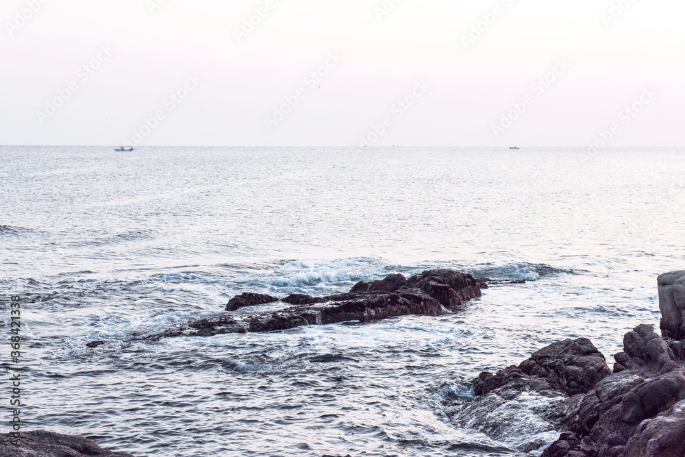 Obraz premium Beautiful rock and waves on the seashore along the coastline.