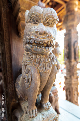 This dog-like creature is one of many  many mythical creatures in the Buddhist religion. This statue is part of the Sanctuary of Truth  an all-wood temple in Pattaya  Thailand.