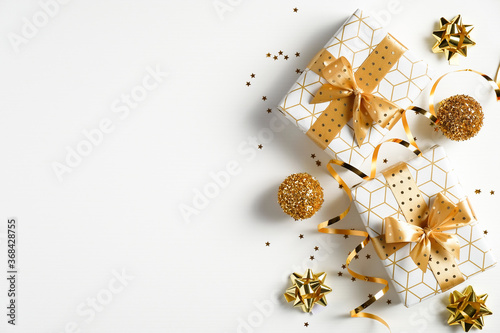 Christmas flat lay composition. Christmas gift boxes, balls and golden decorations on white background. Flat lay, top view, copy space. Xmas banner mockup, New Year greeting card template.