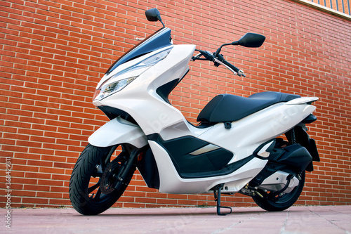 A white motorbike with rusty White motorcycle with a brick wall background