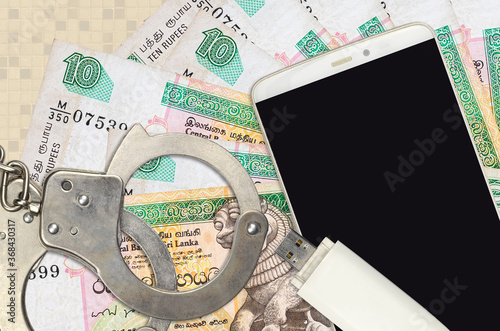 10 Sri Lankan rupees bills and smartphone with police handcuffs. Concept of hackers phishing attacks, illegal scam or malware soft distribution photo