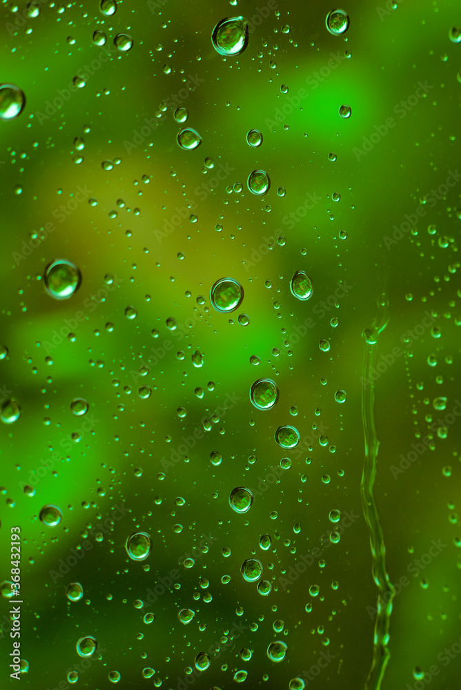 Drops of water on a window pane, raindrops on a window, abstract, colorful