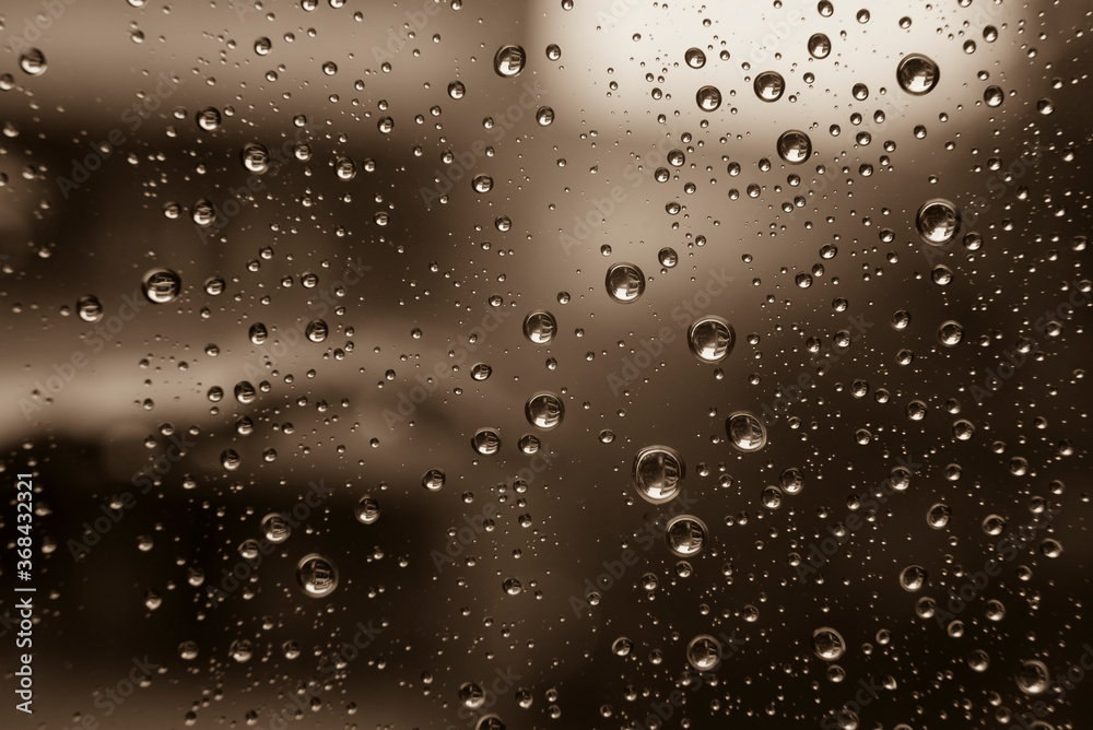 Drops of water on a window pane, raindrops on a window, abstract, black and white photo