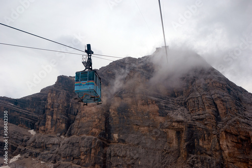 The cable car descends from the mountain in fog, Italy