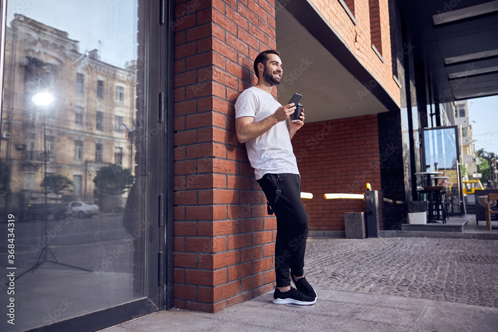 Smiling man with smartphone and coffee