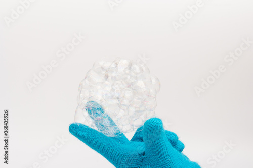 Child in brighte gloves holding soap bubble. happy childhood photo