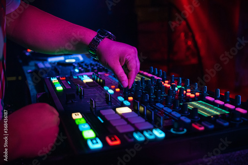 DJ plays music on professional music equipment controller mixer