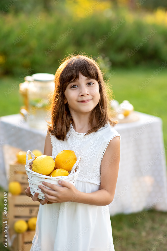Smiling girl holding bowl of lemons. Harvesting festing party. Vitamins and healthy food. Useful citrus fruits as prevention of viral and respiratory diseases. Smiling girl holding bowl of lemons. Harvesting festing party. Vitamins and healthy food. Useful citrus fruits as prevention of viral and respiratory diseases.