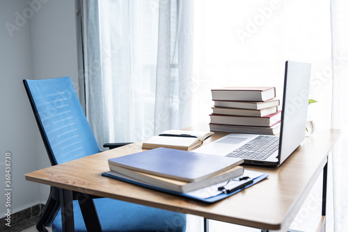 Laptop and book study materials on the desk
