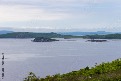View of the Peter the Great Bay from the rocks at the southern tip of Shkot Island in the Vladivostok water area on a summer day. © Сергей Рамильцев