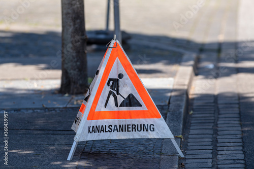 Fotografie Warndreieck , Aufsteller mit der Aufschrift Kanalsanierung