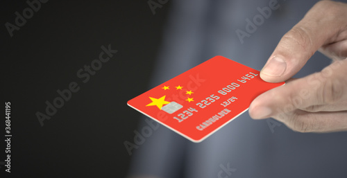 Man gives plastic bank card with printed flag of China. Fictional numbers