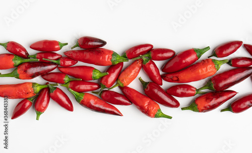 hot red chillies lined up on a white background