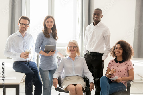 Fototapeta Naklejka Na Ścianę i Meble -  Portrait of happy smiling diverse employees team, department looking at camera, office workers standing, posing for company photo together, showing unity, motivated for business success
