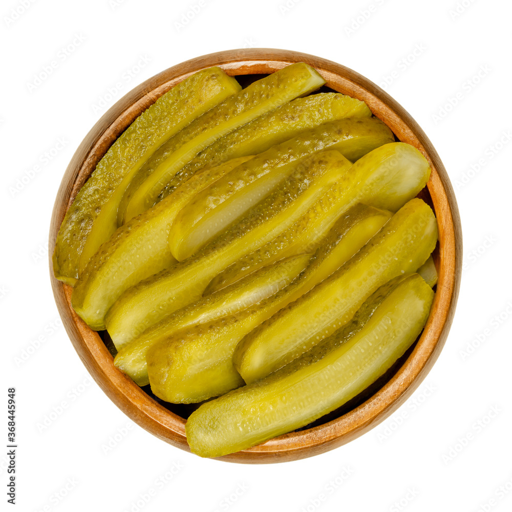 Sliced pickled cucumbers, also known as pickle or gherkin, in a wooden
