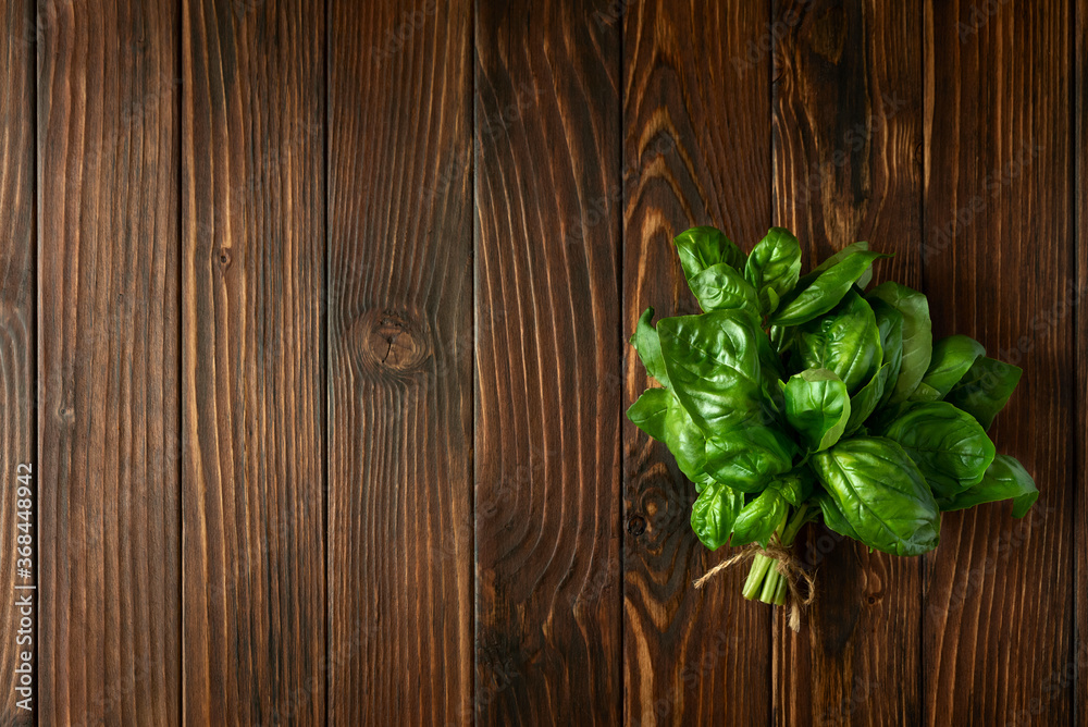 Fresh green basil on brown rustic wooden background. Top view. Flat lay