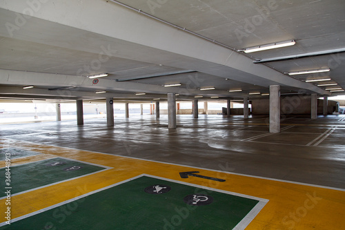 Deserted multi-storey car park with dividing lines under artificial lighting and concrete architecture in central Birmingham - UK 