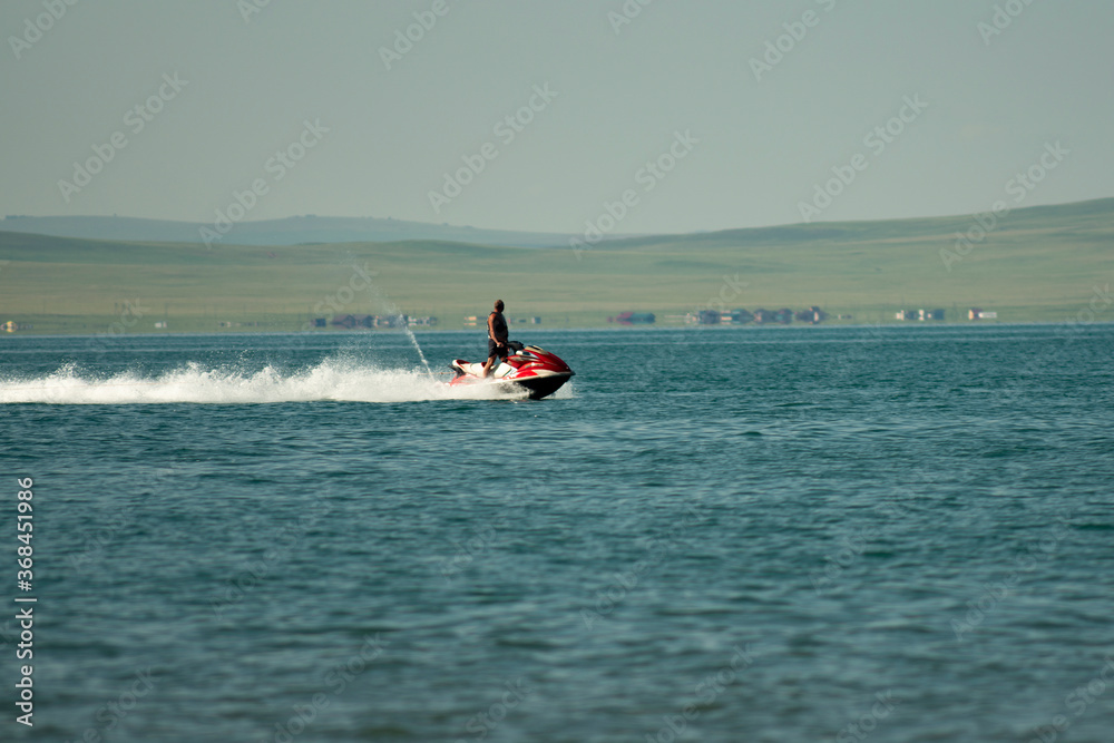 Fototapeta premium A man on a jet ski in the middle of the lake. Speedy rest on the water.