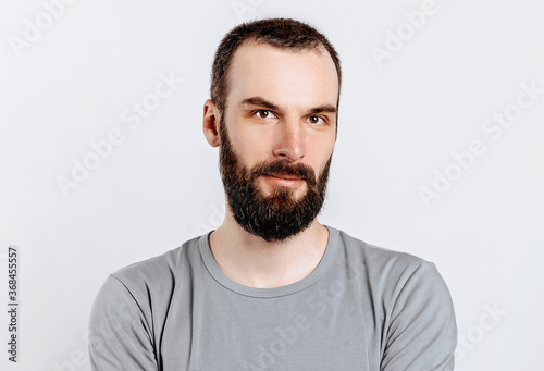 Portrait of a handsome brutal brunette serious man on a white background. The person will soon become the owner of a startup business.