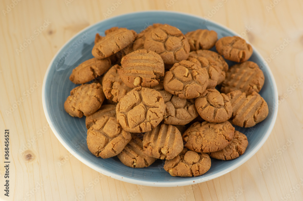 Very tasty peanut butter biscuits on bamboo light brown wooden board, golden baked healthy Very tasty peanut butter biscuits on bamboo light brown wooden board, golden baked healthy