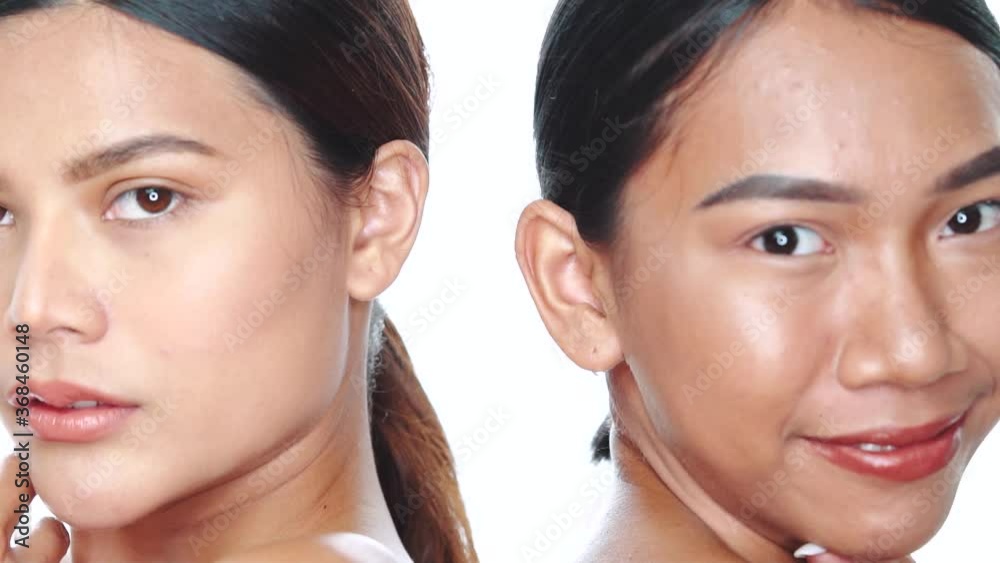 Closeup faces ot two beautiful Asian women looking at the camera over white background. Natural beauty. Skin care cosmetics Closeup faces ot two beautiful Asian women looking at the camera over white background. Natural beauty. Skin care cosmetics