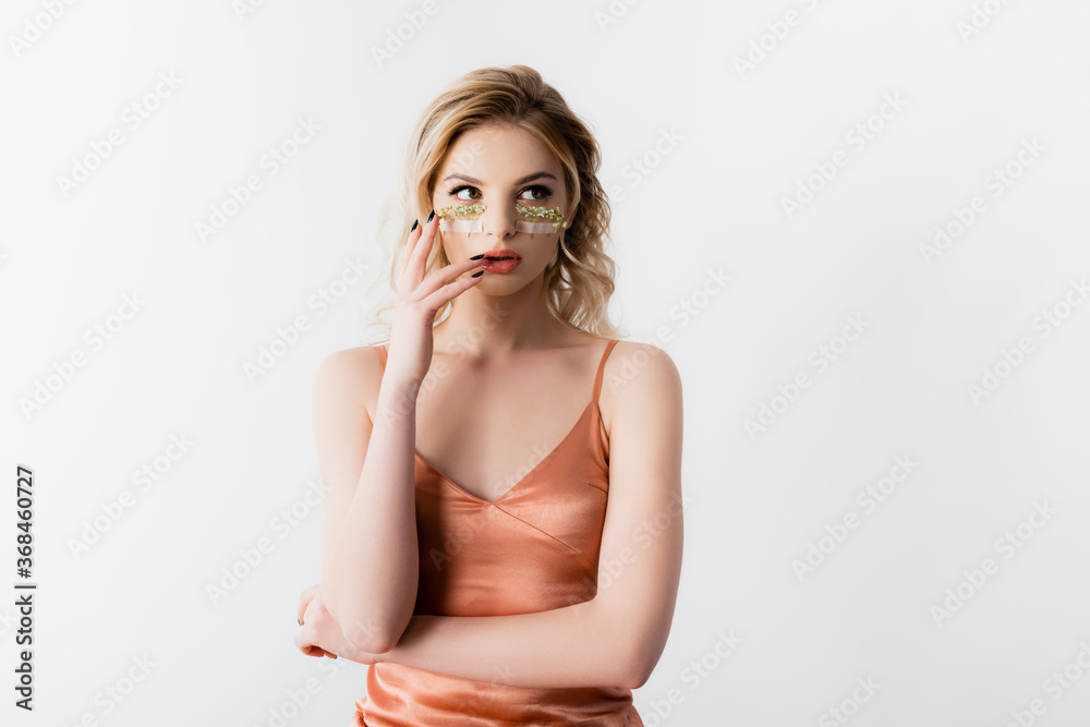 Fototapeta premium beautiful blonde woman in silk dress with wildflowers under eyes isolated on white