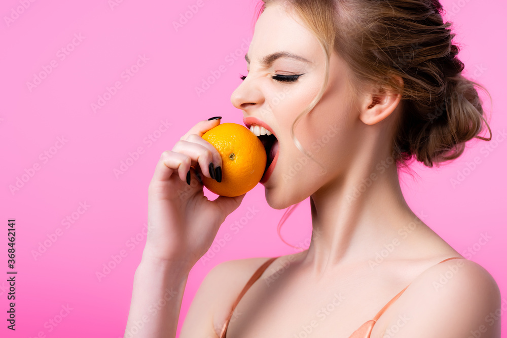 beautiful blonde woman biting ripe orange isolated on pink beautiful blonde woman biting ripe orange isolated on pink
