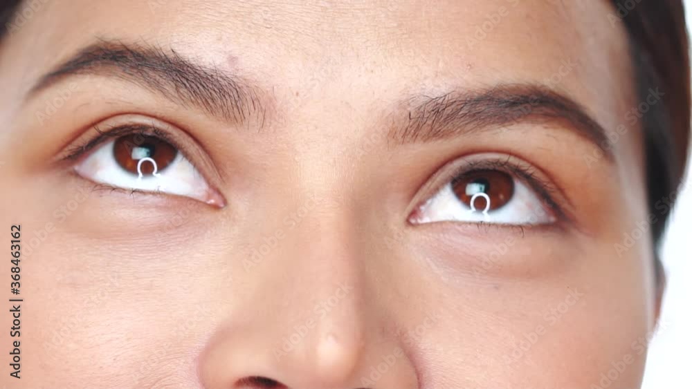 Cropped portrait of woman over white background extreme closeup. Closeup woman looking up and into the camera - video in slow motion Cropped portrait of woman over white background extreme closeup. Closeup woman looking up and into the camera - video in slow motion