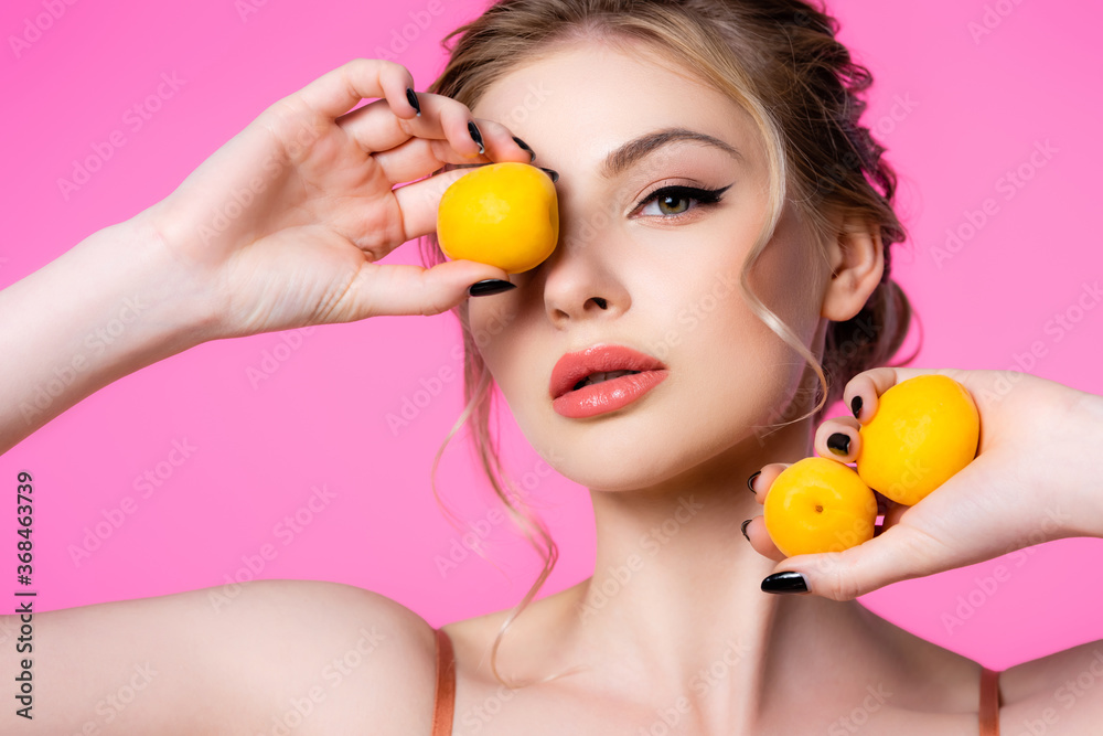 elegant beautiful blonde woman holding apricots isolated on pink elegant beautiful blonde woman holding apricots isolated on pink
