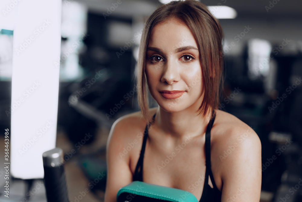 Young beautiful woman training her arms in a gym apparatus Young beautiful woman training her arms in a gym apparatus