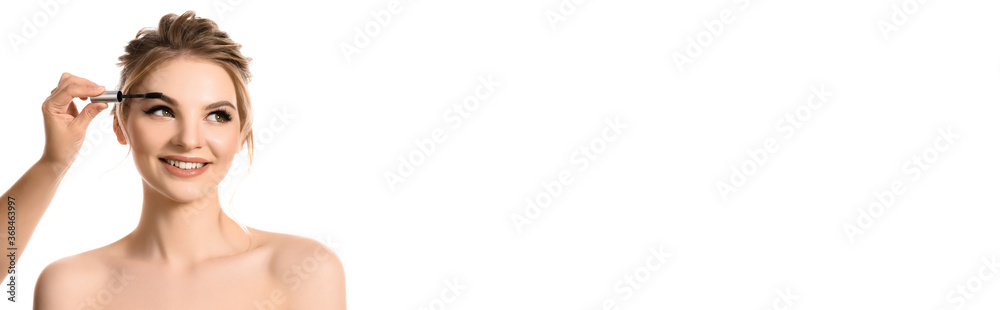 hand with brow mascara near smiling naked beautiful blonde woman isolated on white, panoramic shot