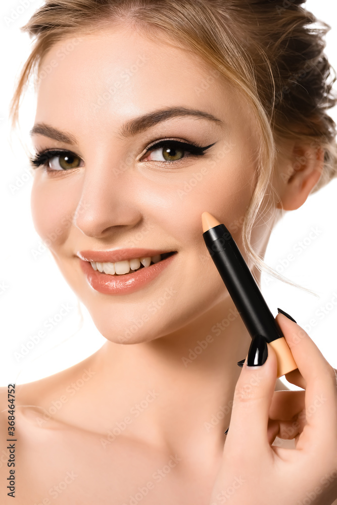 smiling naked beautiful blonde woman with makeup and black nails applying stick concealer isolated on white