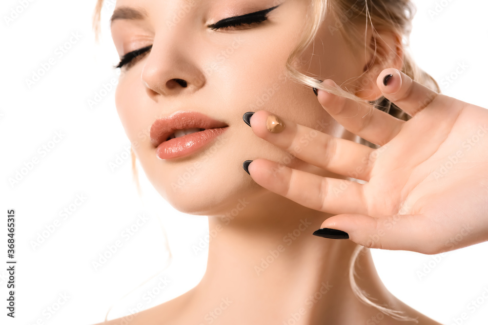 beautiful blonde woman with closed eyes, black nails and face foundation drop on fingers isolated on white
