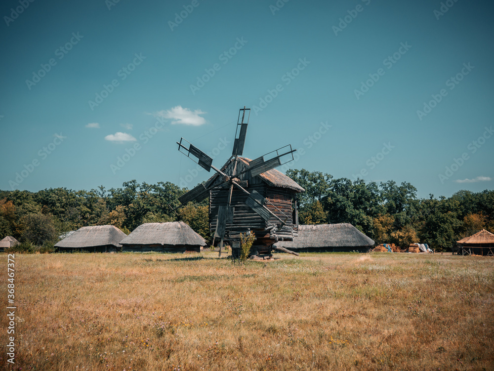 Fototapeta premium The traditional ukrainian wooden wind mill in the Pirogovo historical museum, Kiev, Ukraine