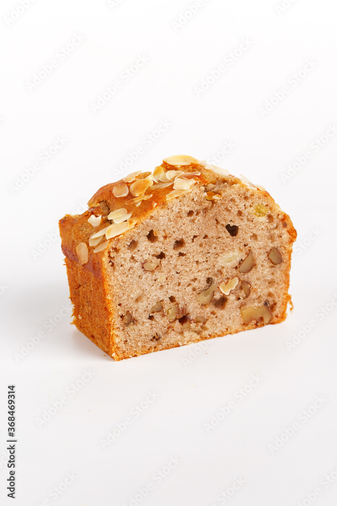 piece of cupcake with raisins and nuts on a white background