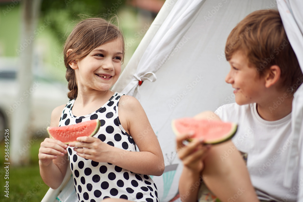 Cheerful children eating watermelon in a camp Cheerful children eating watermelon in a camp