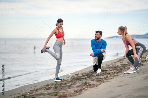 Prepare for Jogging. Group People Exercising On The Beach.