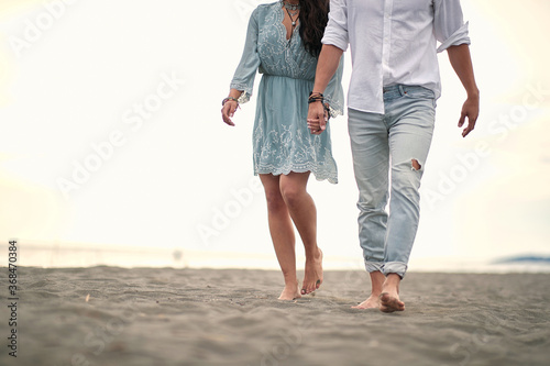 Romantic walk by the sea. Couple holding hands.