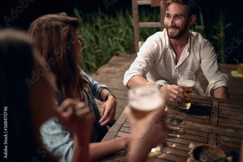 Couple enjoying at evening fun and drinks beer.