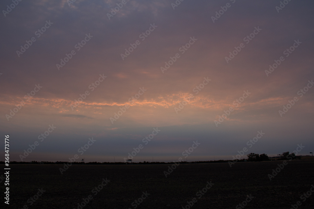 sunrise in the clouds over a field 