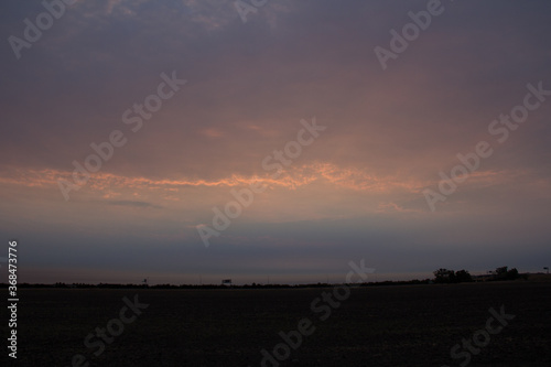 sunrise in the clouds over a field 