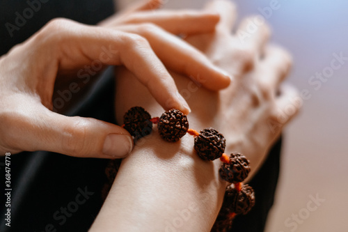 Rudraksha beads bracelet on Caucasian woman's hand, close up shot photo