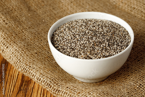 Bowl with raw chia seeds close up