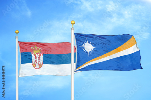 Serbia and Marshall Islands two flags on flagpoles and blue sky