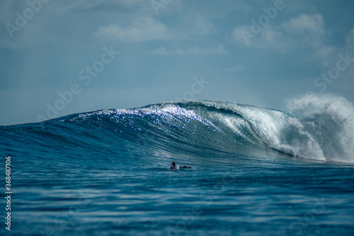 Surfer on perfect blue big tube wave, empty line up, perfect for surfing, clean water in Indian Ocean © Lila Koan