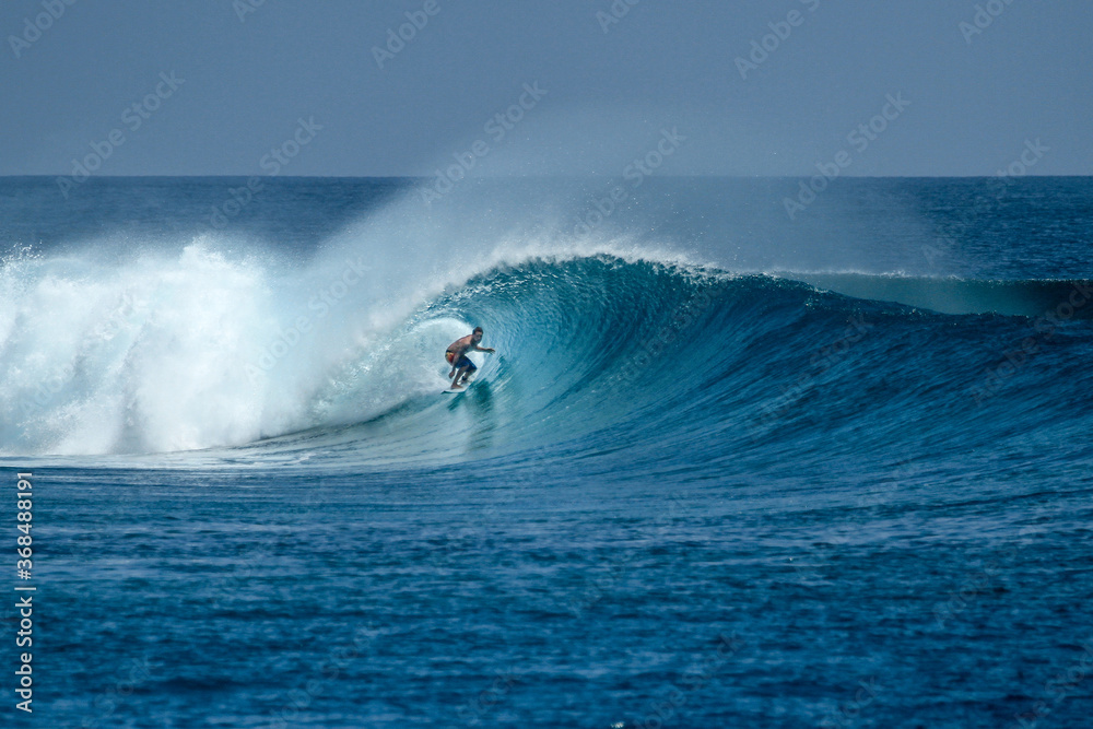 Surfer on perfect blue big tube wave, empty line up, perfect for surfing, clean water in Indian Ocean . Surfer on perfect blue big tube wave, empty line up, perfect for surfing, clean water in Indian Ocean .