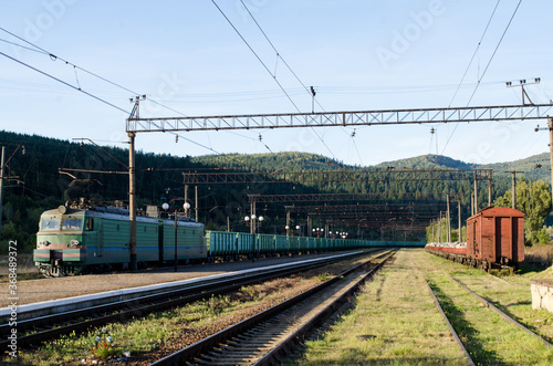 Railway tracks and wagons of the station against the background of the high Carpathian mountains