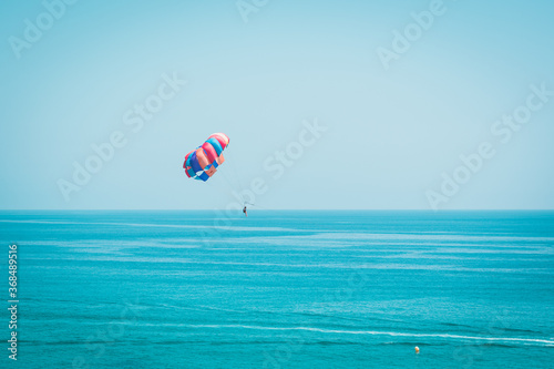 Paraglider flying through the blue sky