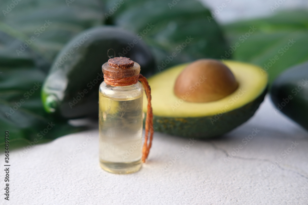 Close up of oil and slice of avocado on wooden table Close up of oil and slice of avocado on wooden table