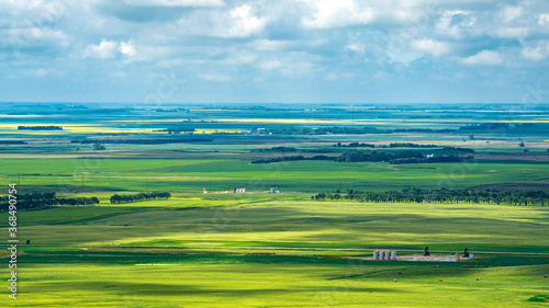 Aerial views Prairie landscapes of yellow and green fields under bold cloudy skies bright lighted areas
